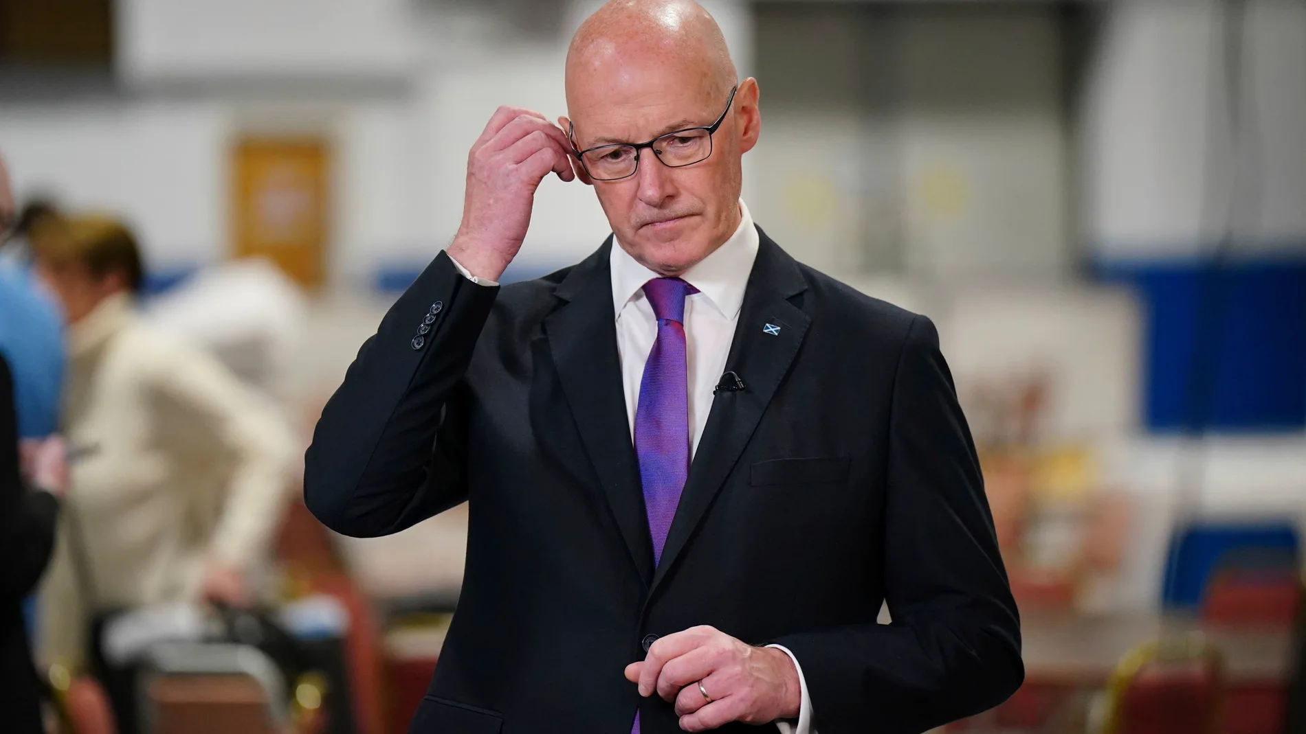 Scottish First Minister and SNP leader John Swinney adjusts his ear piece at Ice Hall in the Dewars Centre, Perth, during the count in the 2024 General Election, Friday July 5, 2024. (Jane Barlow/PA via AP)