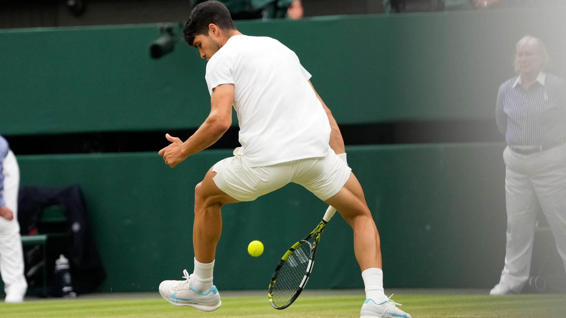 Spain's Carlos Alcaraz plays a shot back between his legs back to Francis Tiafoe of the United States during their third round match at the Wimbledon tennis championships in London, Friday, July 5, 2024. (AP Photo/Alberto Pezzali)