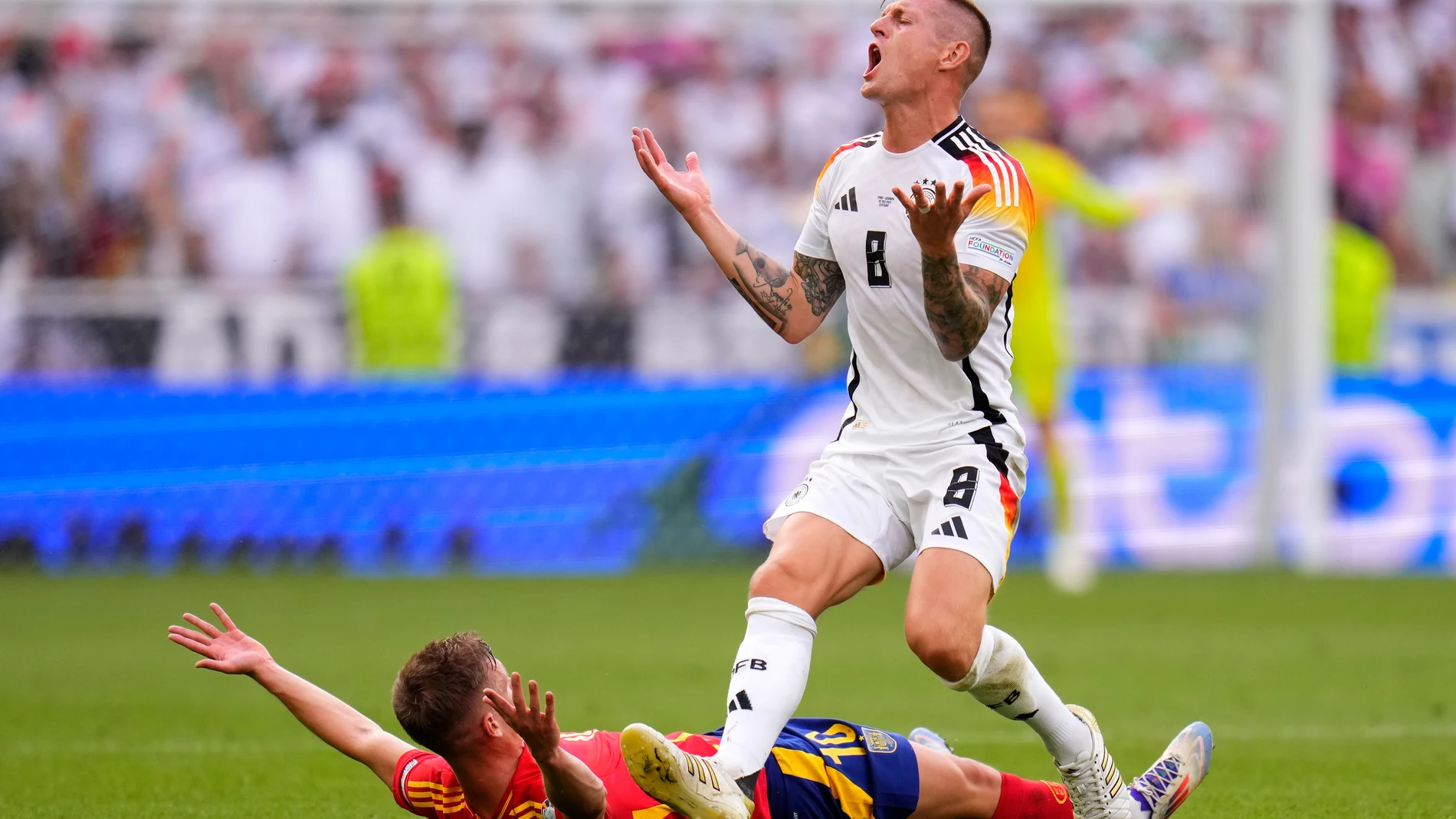 Germany's Toni Kroos, right, and Spain's Dani Olmo gesture during a quarter final match between Germany and Spain at the Euro 2024 soccer tournament in Stuttgart, Germany, Friday, July 5, 2024. (AP Photo/Manu Fernandez)