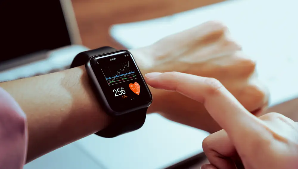 Primer plano de la mano tocando el reloj inteligente con la aplicación de salud en la pantalla.