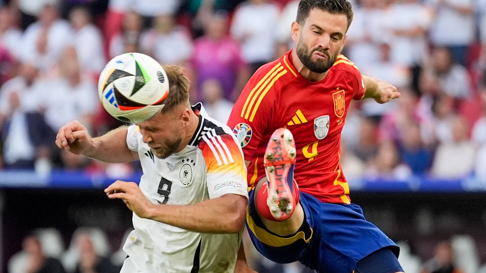 Germany's Niclas Fuellkrug, left, tussles for the ball with Spain's Nacho during a quarter final match between Germany and Spain at the Euro 2024 soccer tournament in Stuttgart, Germany, Friday, July 5, 2024. (AP Photo/Ariel Schalit)