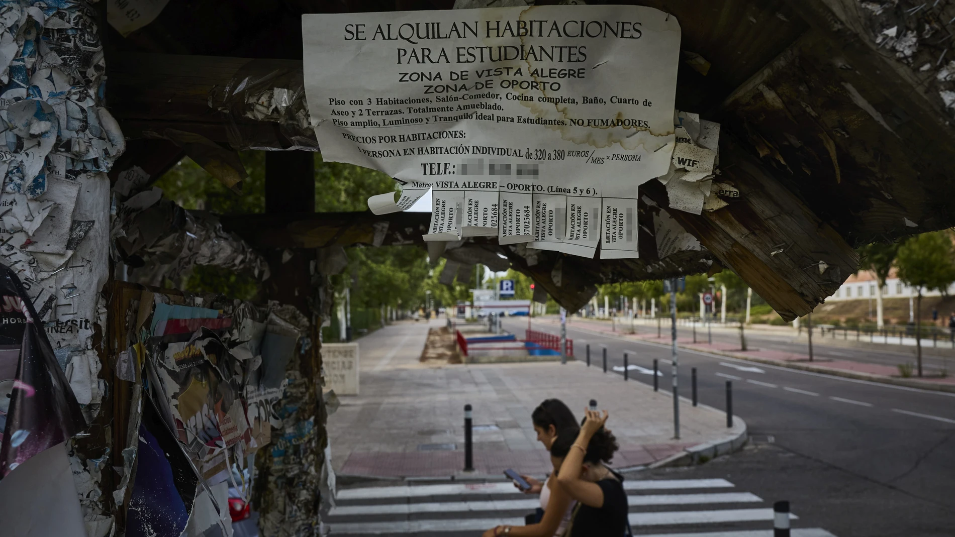 Carteles con ofertas de alquiler de habitaciones en Madrid.
