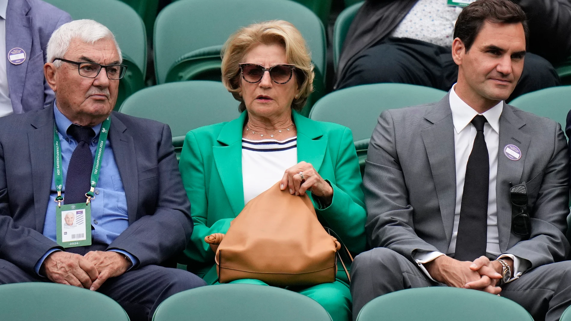 Roger Federer, right, sits with his parents , Robert and Lynette as they watch a third round match between Denis Shapovalov of Canada and Ben Shelton of the United States at the Wimbledon tennis championships in London, Saturday, July 6, 2024. (AP Photo/Alberto Pezzali)