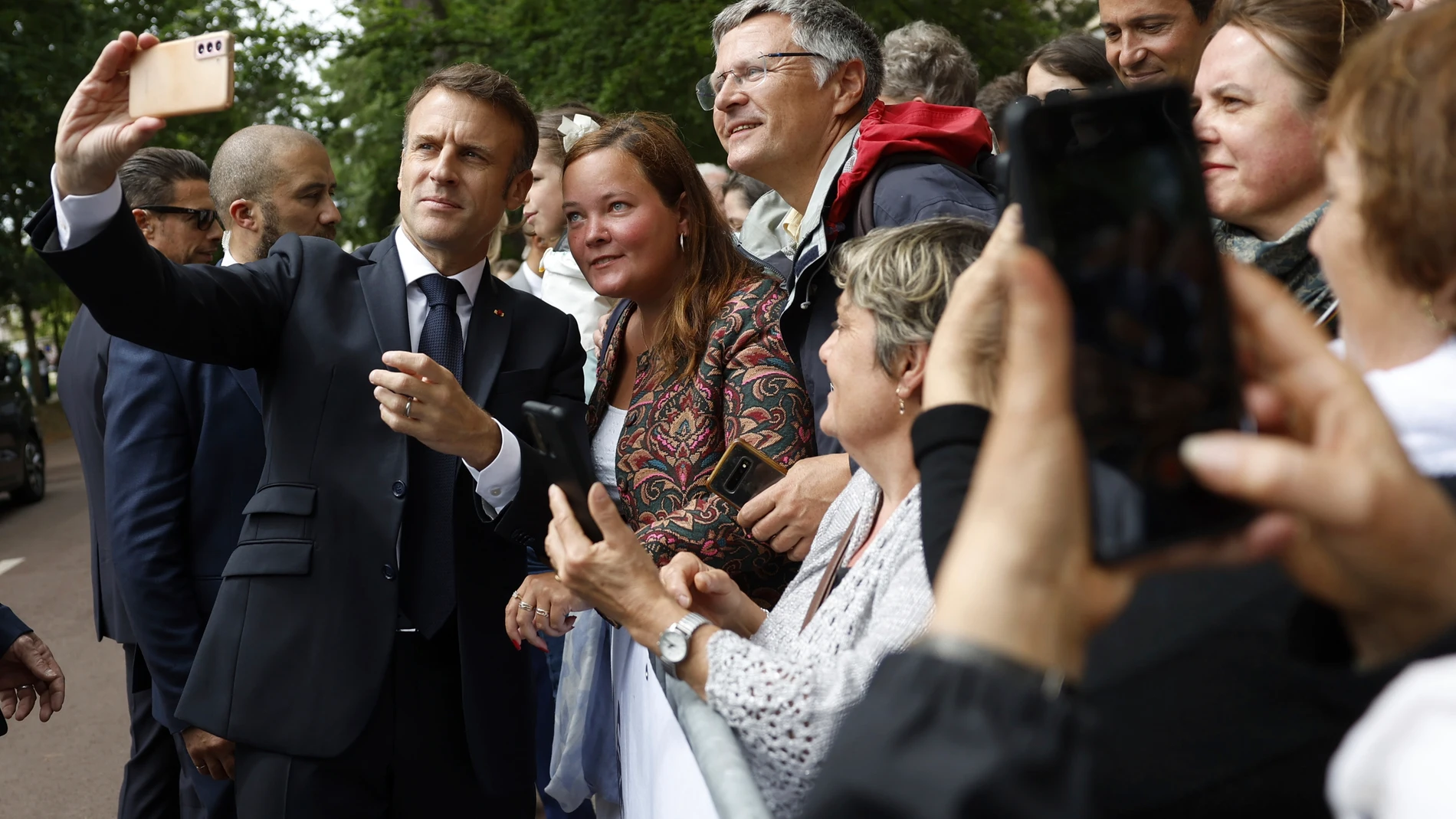French President Emmanuel Macron makes a selfie for supporters after voting for the second round of the legislative elections in Le Touquet-Paris-Plage, northern France, Sunday July 7 2024. Voting has begun in mainland France on Sunday in pivotal runoff elections that could hand a historic victory to Marine Le Pen's far-right National Rally and its inward-looking, anti-immigrant vision — or produce a hung parliament and political deadlock. (Mohammed Badra, Pool via AP)