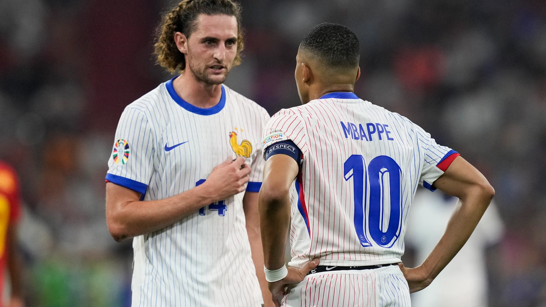 Adrien Rabiot of France, left, talks with Kylian Mbappe during a semifinal match between Spain and France at the Euro 2024 soccer tournament in Munich, Germany, Tuesday, July 9, 2024. (AP Photo/Antonio Calanni)