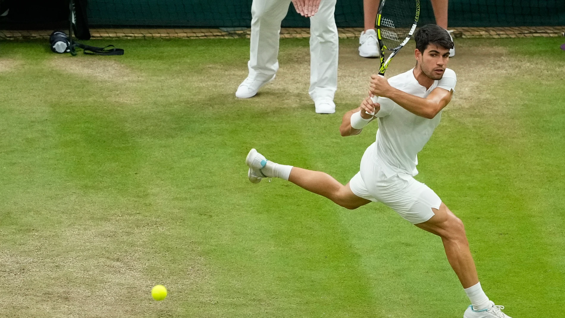 Carlos Alcaraz of Spain plays a backhand return to Tommy Paul of the United States during their quarterfinal match at the Wimbledon tennis championships in London, Tuesday, July 9, 2024. (AP Photo/Mosa'ab Elshamy)