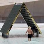 Un hombre se refresca en una de los lagos de la Ciudad de las Artes y de las Ciencias de Valencia