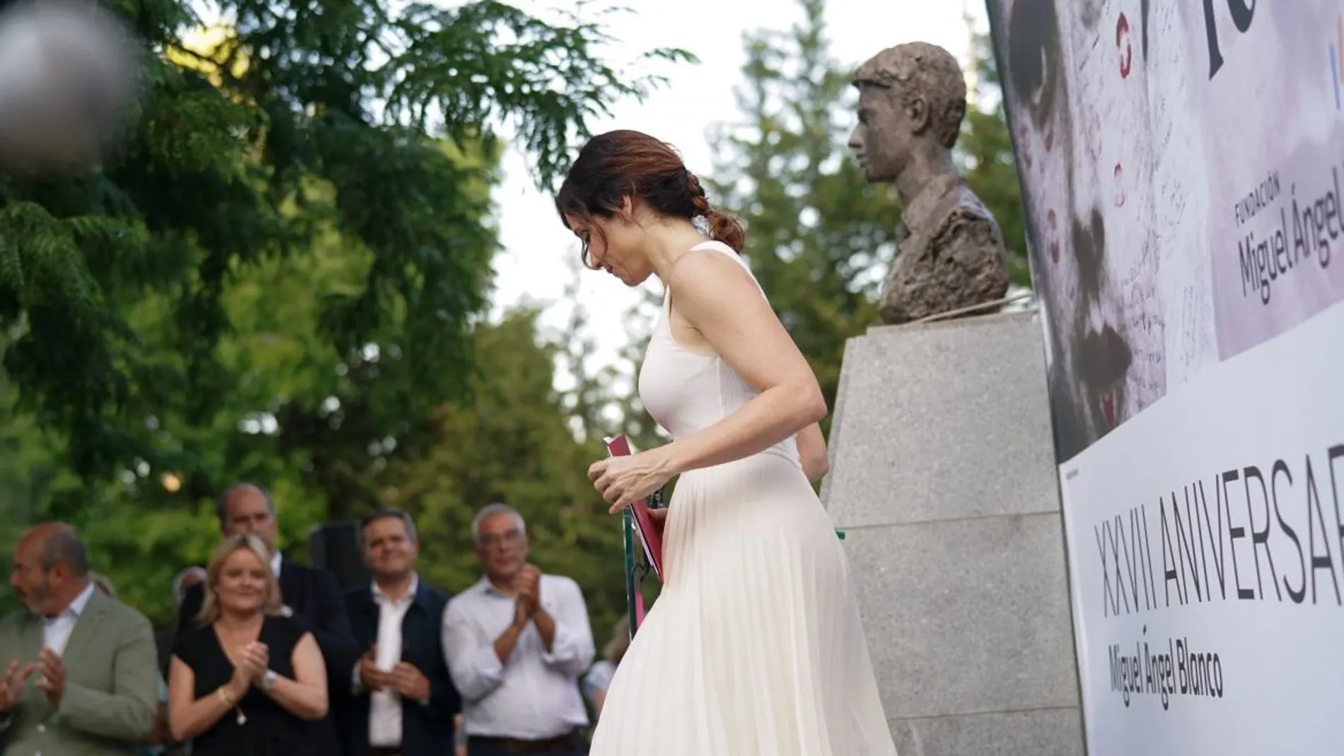 Ayuso con vestido blanco plisado.