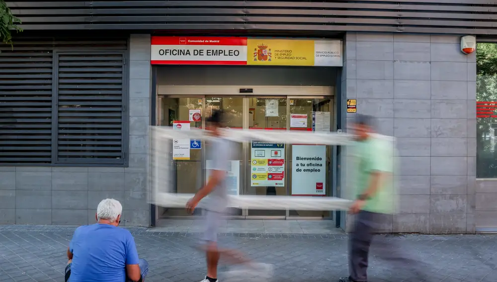Varias personas pasan por delante de la oficina del SEPE del Paseo de las Acacias, en Madrid (España).