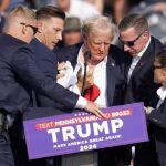 Republican presidential candidate former President Donald Trump is helped off the stage at a campaign event in Butler, Pa., on Saturday, July 13, 2024
