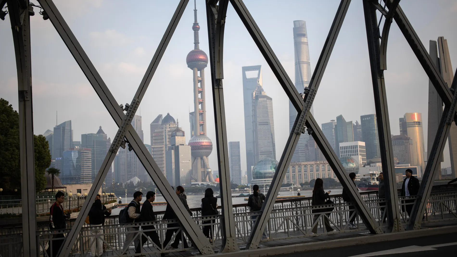Shanghai (China), 21/11/2024.- People walk along a bridge with high-rise buildings seen in the background, in the Bund district of Shanghai, China, 21 November 2024. EFE/EPA/ANDRES MARTINEZ CASARES