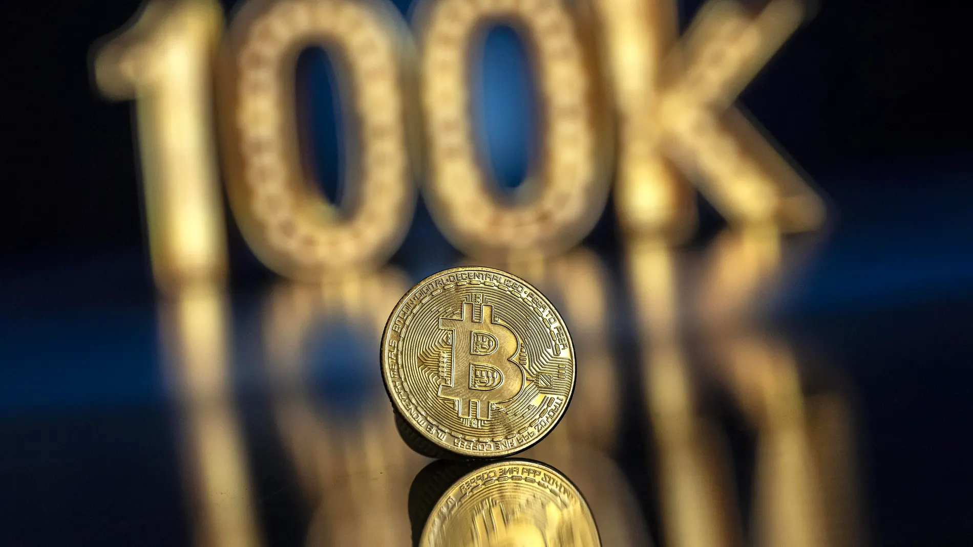 Lugano (Switzerland), 22/11/2024.- An illustration shows a symbolic Bitcoin in front of a 100k sign, in Lugano, Switzerland, 22 November 2024. The world's most popular cryptocurrency hit a record high on 21 November, approaching the 100,000 US dollar (USD) mark. Bitcoin has been regularly hitting fresh records this month on hopes that US President-elect Donald Trump will usher in a golden age of cryptocurrencies. (Suiza) EFE/EPA/PABLO GIANINAZZI