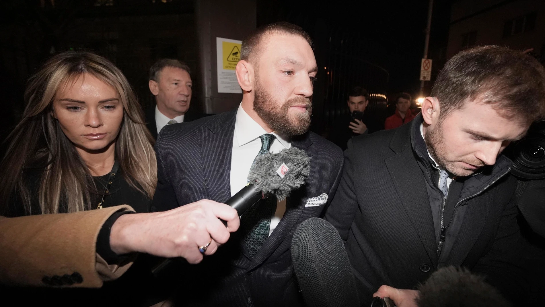 Conor McGregor, center, and partner Dee Devlin, left, leave the High Court in Dublin, Ireland, Friday, Nov. 22, 2024, after a civil jury found that mixed martial arts fighter sexually assaulted a woman in a hotel penthouse after a night of heavy partying. (Brian Lawless/PA via AP)