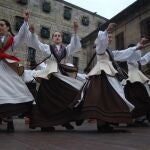 Agrupación folclórica gallega vestida con el traje tradicional gallego bailando.