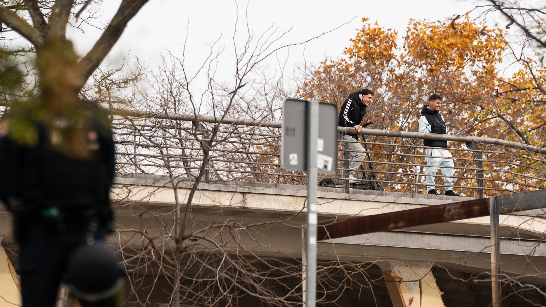 Dos jóvenes observan desde un puente el desalojo por parte de la Policía Nacional del centro social okupado ‘La Atalaya’ en Puente de Vallecas, a 26 de noviembre de 2024, en Madrid (España). El centro se trata de un antiguo instituto en desuso que fue okupado y reconvertido en centro social hace una década, en diciembre de 2014, con la organización de asambleas, conciertos, rocódromo o talleres. El dispositivo policial ha arrancado a las 9:30 de la mañana con la presencia de indicativos de la...