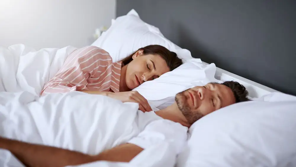 Pareja durmiendo en una cama