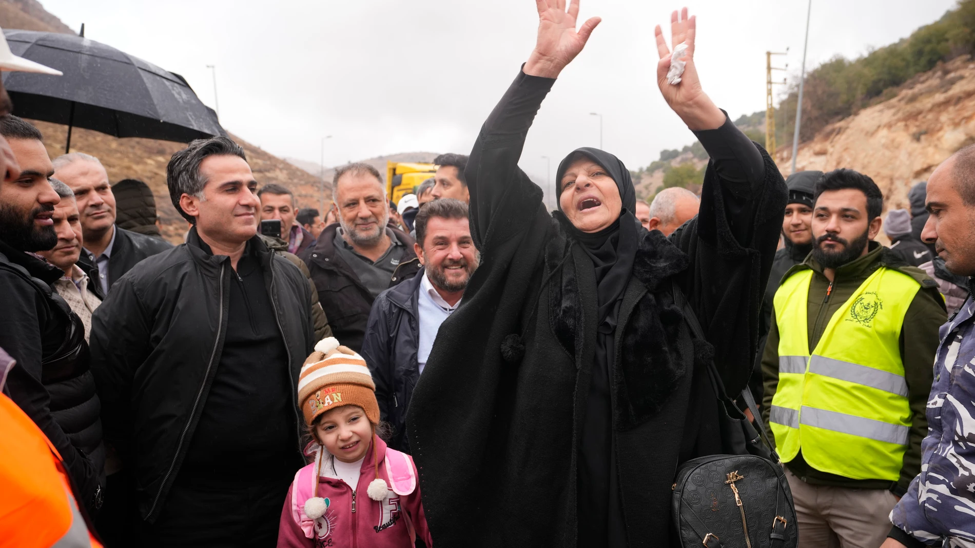 Caretaker Transportation Minister Ali Hamieh, left, welcomes displaced residents returning from Syria at the Masnaa border crossing, eastern Lebanon, following a ceasefire between Israel and Hezbollah on Wednesday, Nov. 27, 2024. (AP Photo/Hassan Ammar)