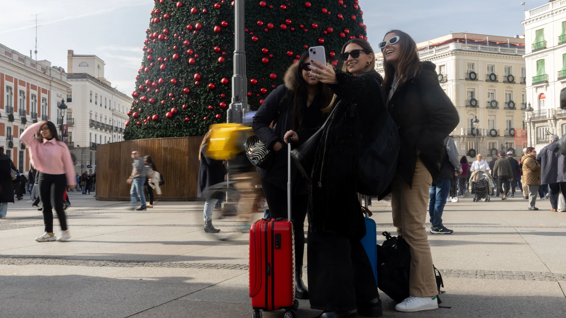 Varias turistas se hacen una foto junto al árbol de Navidad de la Puerta del Sol, a 29 de noviembre de 2024, en Madrid (España). La ciudad de Madrid espera batir récord de turistas durante esta Navidad y superar el 90% de ocupación hotelera, tal y como ha trasladado este miércoles el alcalde, José Luis Martínez-Almeida. Desde la Casa de la Villa, el regidor ha subrayado ante los medios de comunicación que espera superar el récord que ya alcanzaron el año pasado en cuanto a número de visitante...