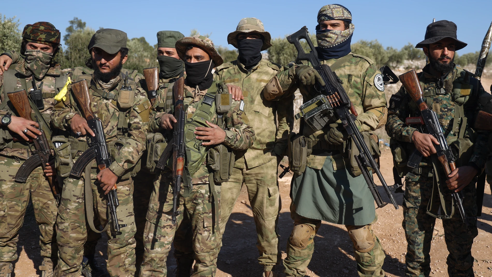 Syrian opposition soldiers stand in formation after entering the village of Anjara, western outskirts of Aleppo, Syria, Thursday Nov. 29, 2024. Syrian armed groups launched a large-scale attack on areas controlled by government forces and seized territory in northwestern Syria, opposition groups said Thursday.(AP Photo/Omar Albam)