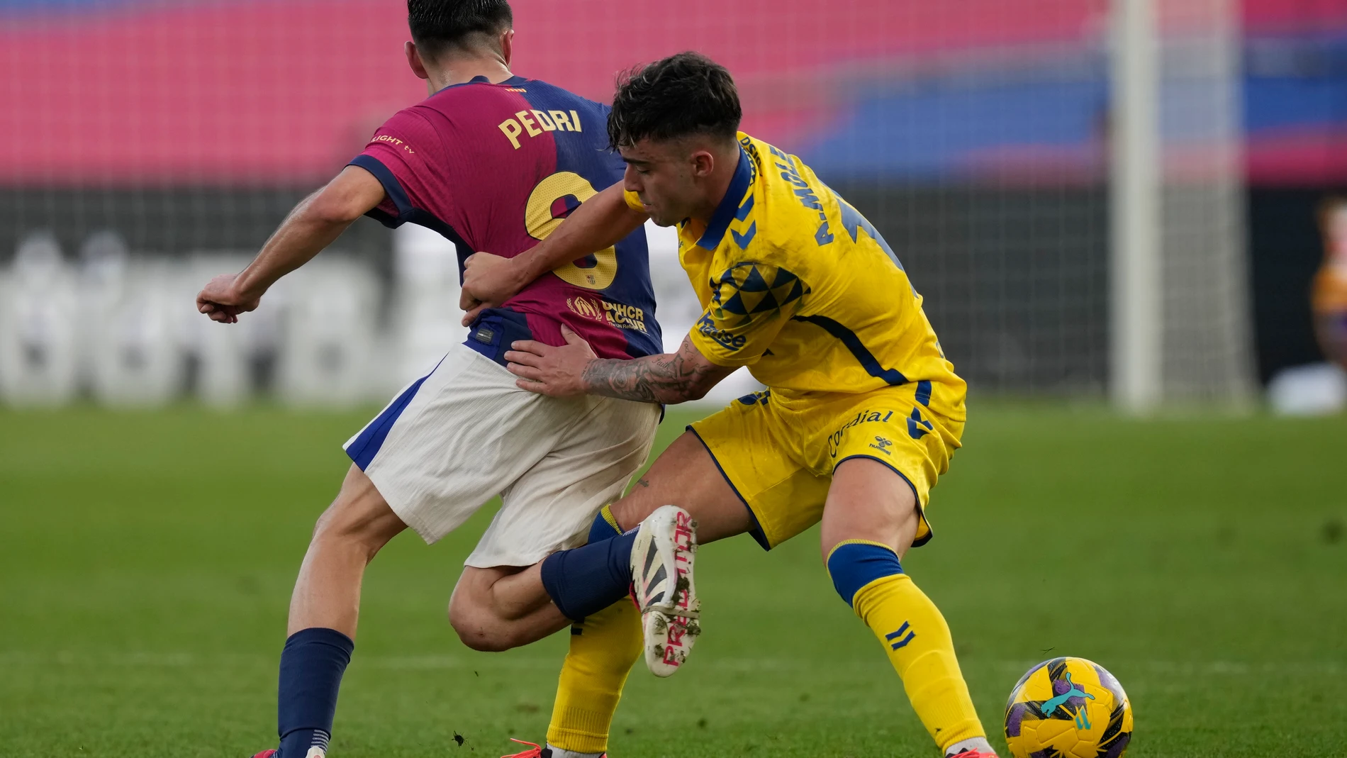 BARCELONA, 30/11/2024.- El centrocampista de Las Palmas Alberto Moleiro (d) disputa un balón con el centrocampista del FC Barcelona Pedri (i) durante su partido de LaLiga en el Estadio Olímpico Lluís Companys en Barcelona este sábado. EFE/Enric Fontcuberta