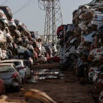 Cientos de coches arrasados por la inundación han sido depositados en un descampado en la localidad de Paiporta
