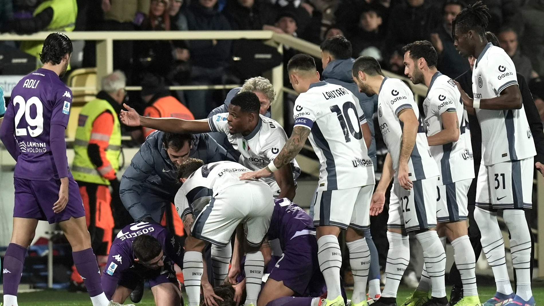 Fiorentina's Edoardo Bove, injured, is surrounded by players after collapsing during the Serie A soccer match between Fiorentina and Inter at the Artemio Franchi Stadium in Florence, Italy, Sunday Dec. 1, 2024 (Massimo Paolone/LaPresse via AP)