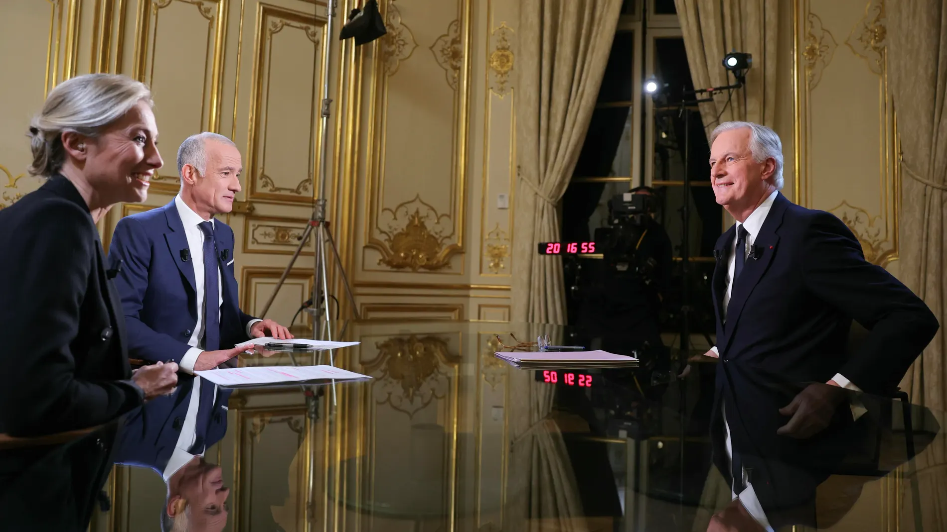 Paris (France), 03/12/2024.- France's Prime Minister Michel Barnier (R) delivers remarks during a televised interview broadcast by news anchors Gilles Bouleau (C) and Anne-Sophie Lapix, on the evening news on French TV channels, at Hotel Matignon in Paris, France, 03 December 2024. Opposition lawmakers vowed to topple the minority government of Barnier in a no-confidence vote after just three months in office. (Francia) EFE/EPA/THOMAS SAMSON / POOL MAXPPP OUT