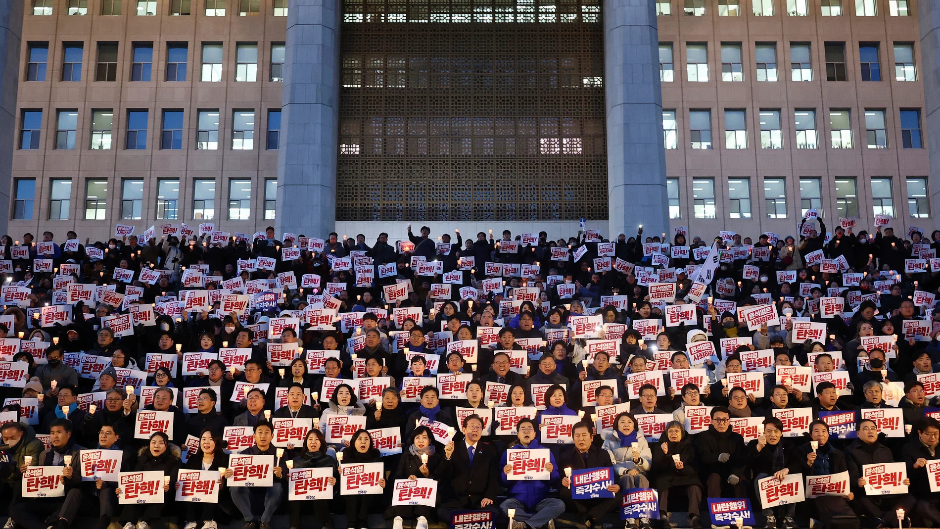 Members of South Korea's main opposition Democratic Party stage a rally against the President Yoon Suk Yeol at the National Assembly in Seoul, South Korea, Wednesday, Dec. 4, 2024. The signs read "Yoon Suk Yeol should resign." (Ryu Hyung-seok/Yonhap via AP)
