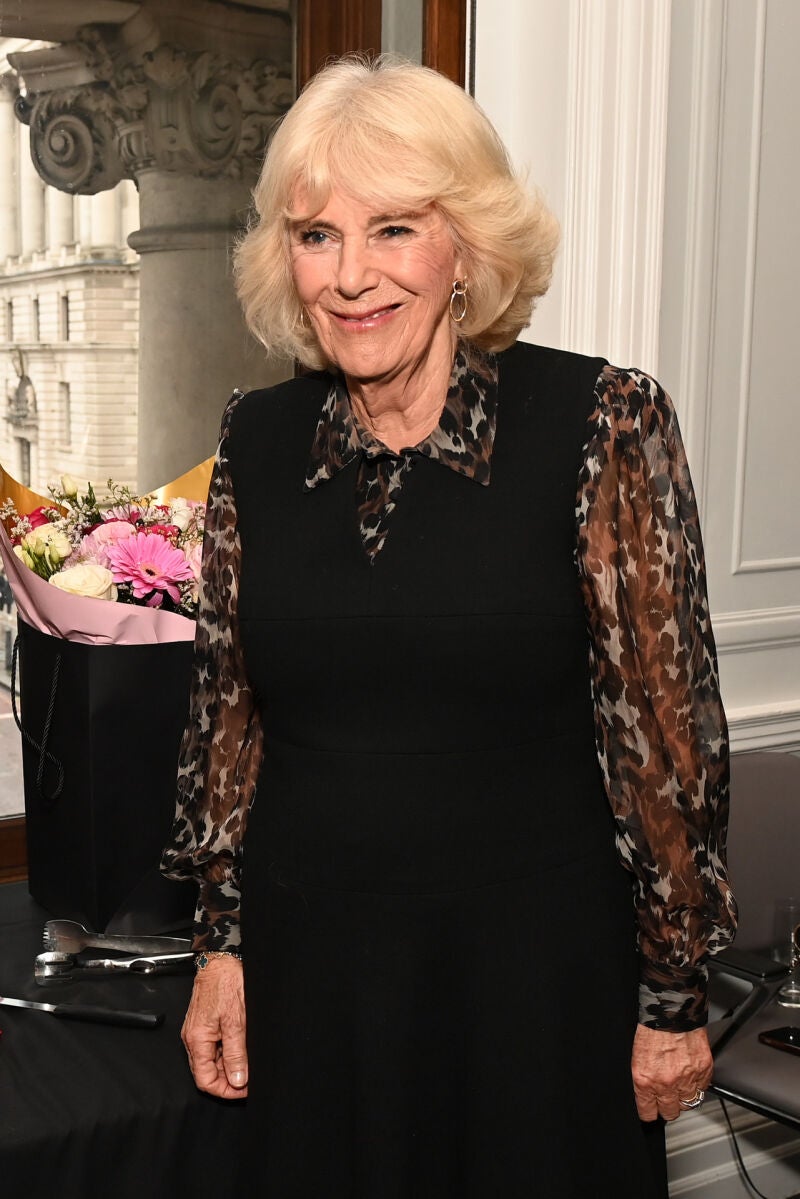 La reina Camilla vuelve al trabajo con un vestido pichi de color negro