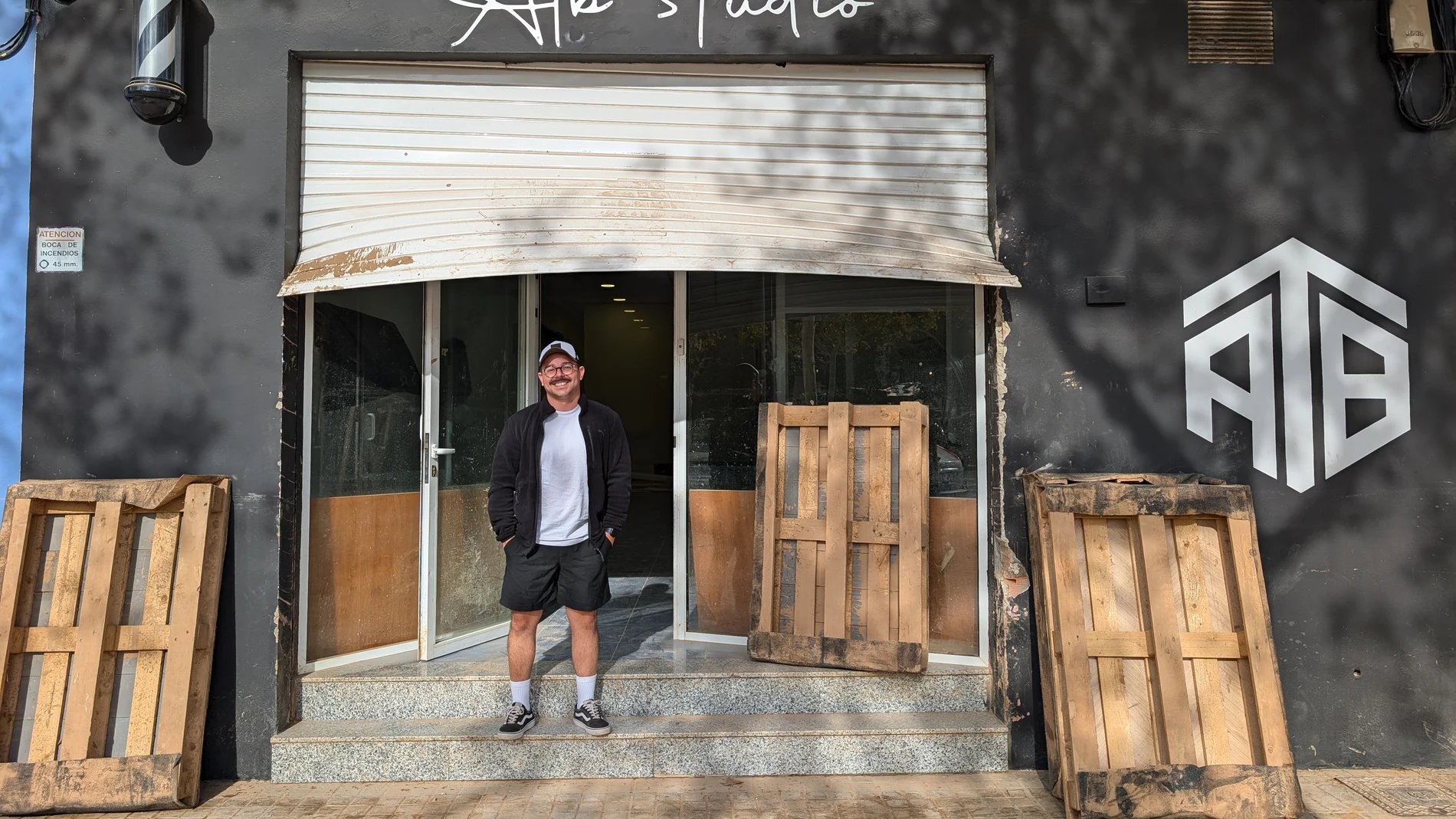 Adonay Rivera posa frente a su barbería en Aldaia