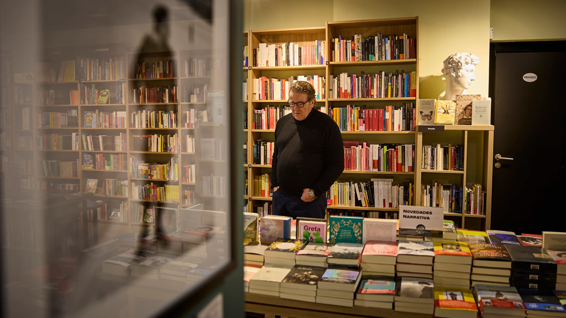 José Parra observa algunos de los libros que vende en su librería, en un momento de la entrevista el pasado 6 de diciembre