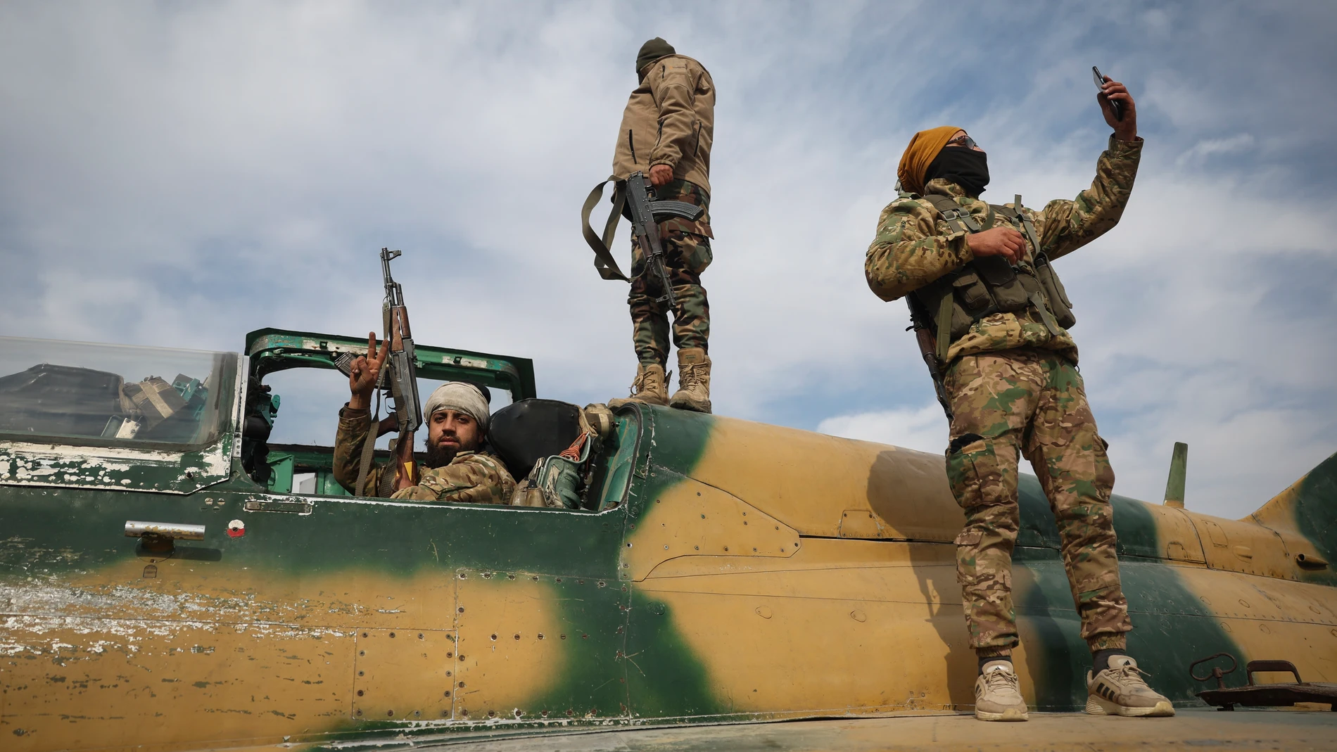 Syrian opposition fighters stand atop a seized Syrian airforce fighter plane at the Hama airport, Syria, Friday Dec. 6, 2024. (AP Photo/Ghaith Alsayed)