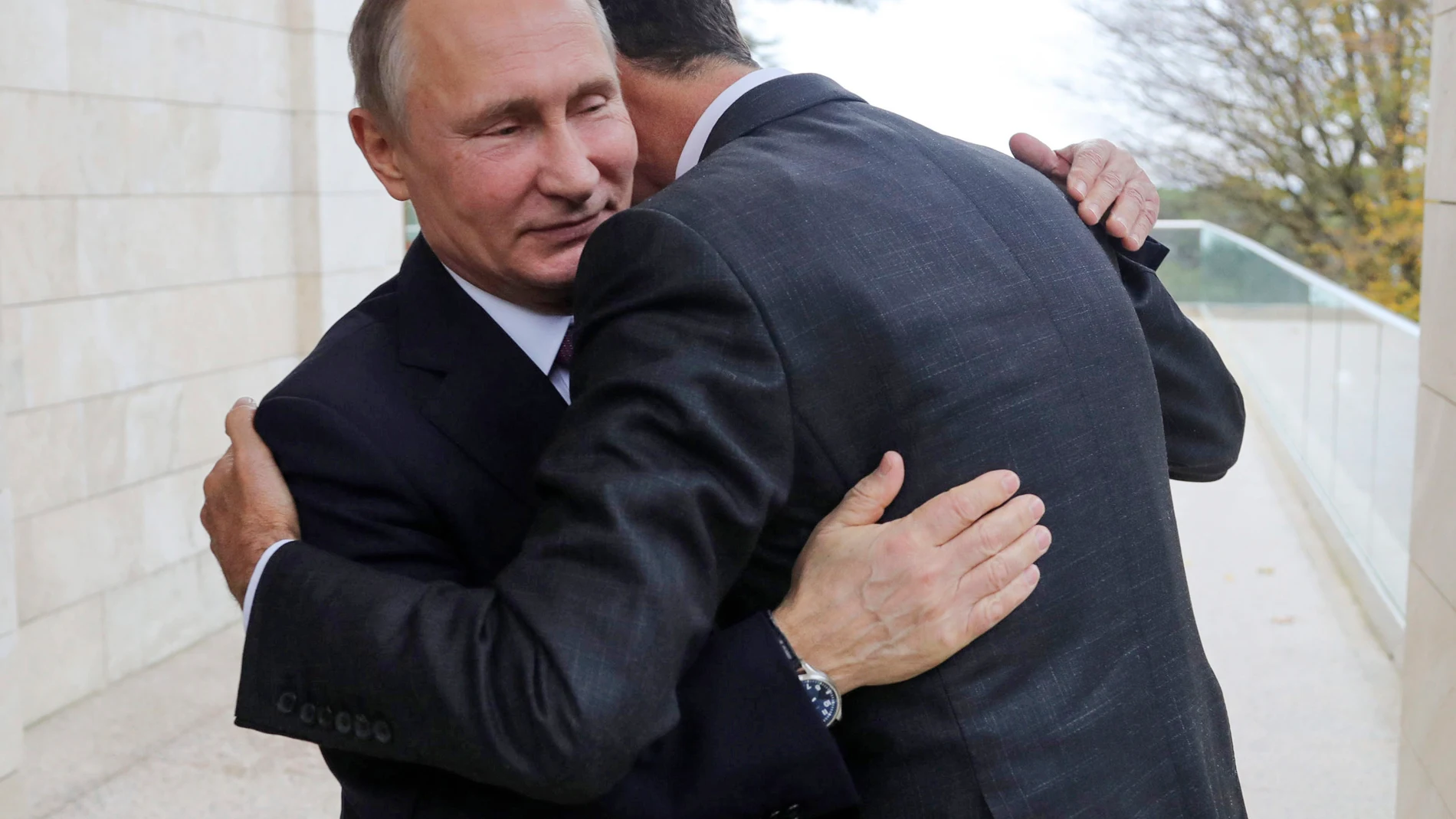 FILE - In this Nov. 20, 2017, photo, Russian President Vladimir Putin, left, embraces Syrian President Bashar Assad in the Bocharov Ruchei residence in the Black Sea resort of Sochi, Russia. (Mikhail Klimentyev, Kremlin Pool Photo via AP, File)
