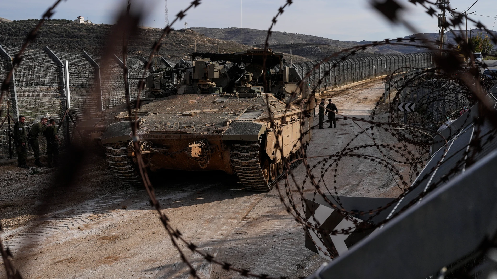 Israeli soldiers stand next to armored vehicles parked near the so-called Alpha Line that separates the Israeli-annexed Golan Heights from Syria, in the town of Majdal Shams, Monday, Dec. 9, 2024. (AP Photo/Matias Delacroix)