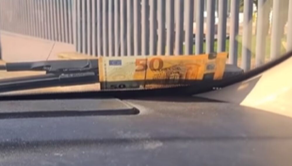 Billete de 50 en el limpiaparabrisas
