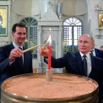 Bachar al Asad y Vladimir Putin encienden una vela en una iglesia ortodoxa en Damasco en 2020