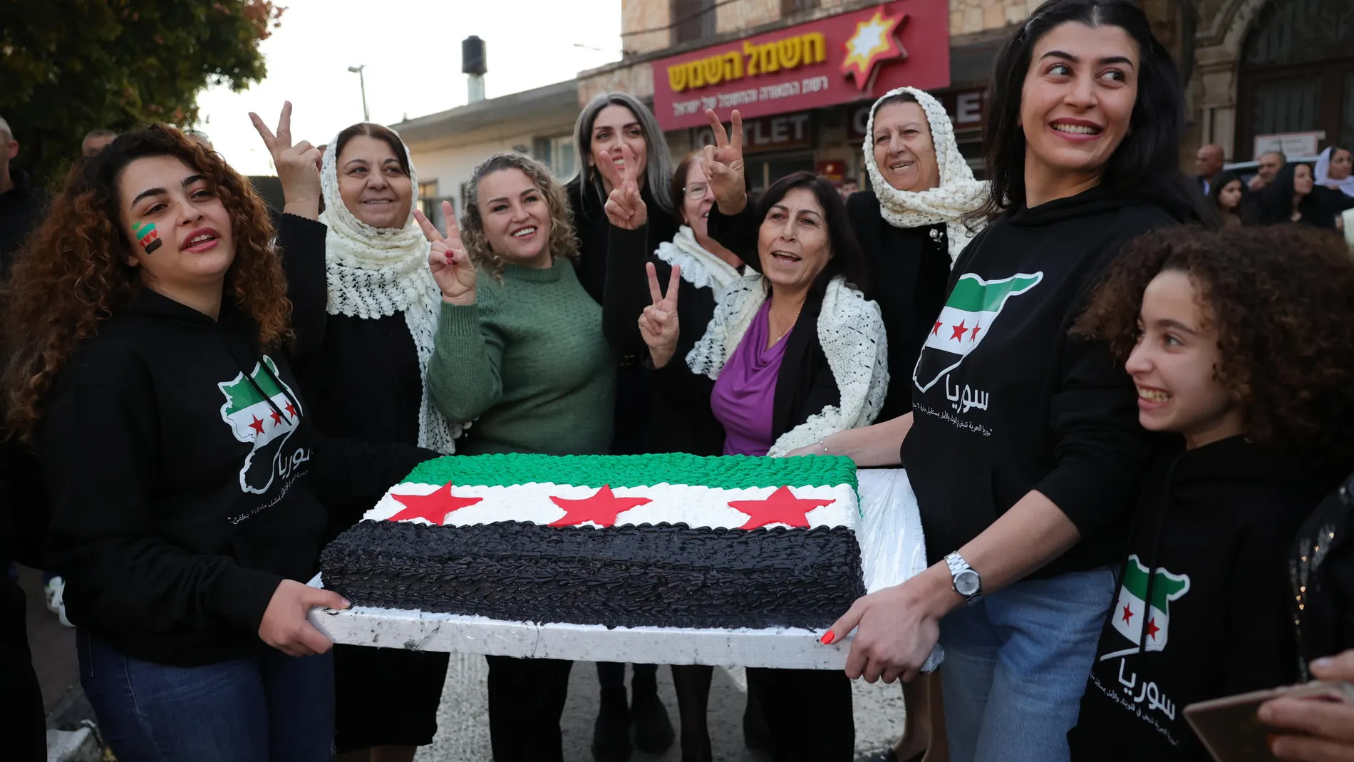 Majdal Shams (Israel), 09/12/2024.- Supporters of the Syrian opposition show a cake with the colors of the Syrian opposition flag as people celebrate the rebel takeover of Damascus, in the village of Majdal Shams, in the Israeli-annexed Golan Heights, 09 December 2024. Syrian rebels entered Damascus on 08 December 2024 and announced in a televised statement the 'Liberation of the city of Damascus and the overthrow of Bashar al-Assad', as well as the release of all the prisoners. (Siria, Damas...
