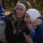 Dos mujeres con familiares en la terrorífica prisión de Saydnaya lloran en su exterior