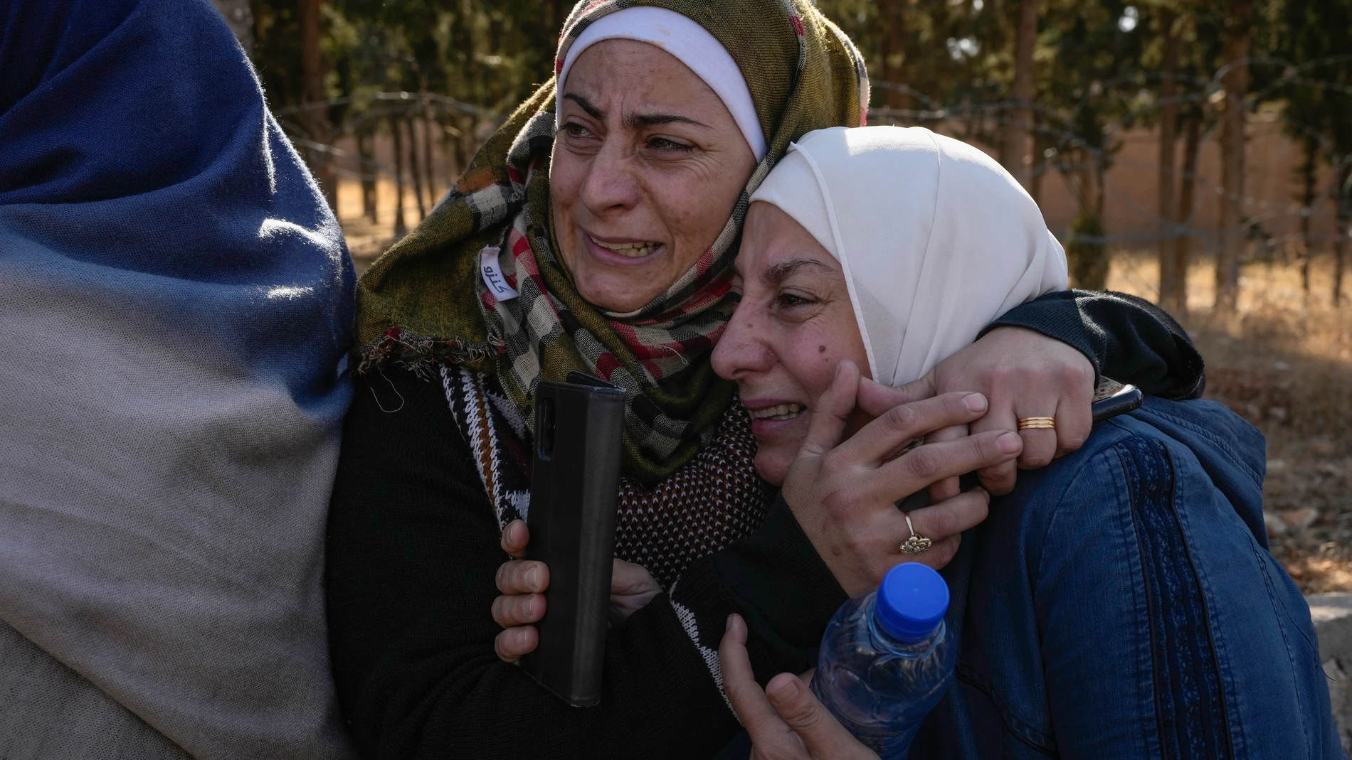 Two women whose relatives were imprisoned embrace outside the infamous Saydnaya military prison, just north of Damascus, Syria, Monday, Dec. 9, 2024. Thousands of inmates were released after Bashar Assad's regime was overthrown on Sunday, and crowds of people entered the prison, known as the "human slaughterhouse," hoping to find relatives who had been held there. (AP Photo/Hussein Malla)