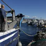 Un pescador observa los demás barcos de arrastre sin salir en el puerto de La Caleta de Vélez-Málaga (Málaga), este martes en el que los pescadores del Mediterráneo han amarrado sus barcos contra la propuesta de la Comisión Europea (CE), que recorta un 79 % los días en el mar, hasta las 27 jornadas al año, para los barcos arrastreros.