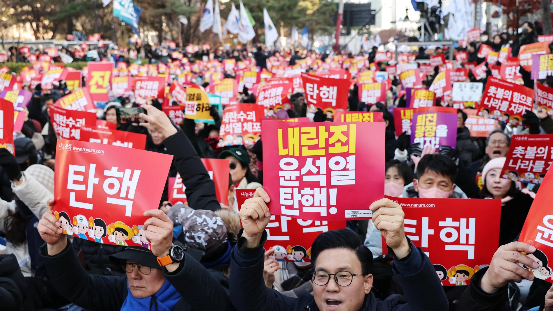 Protesters hold placards calling for the impeachment of President Yoon Suk Yeol in front of the National Assembly in Seoul, South Korea, 07 December 2024. Yoon apologised to the nation in a short televised address ahead of a vote on his impeachment in the National Assembly on 07 December.