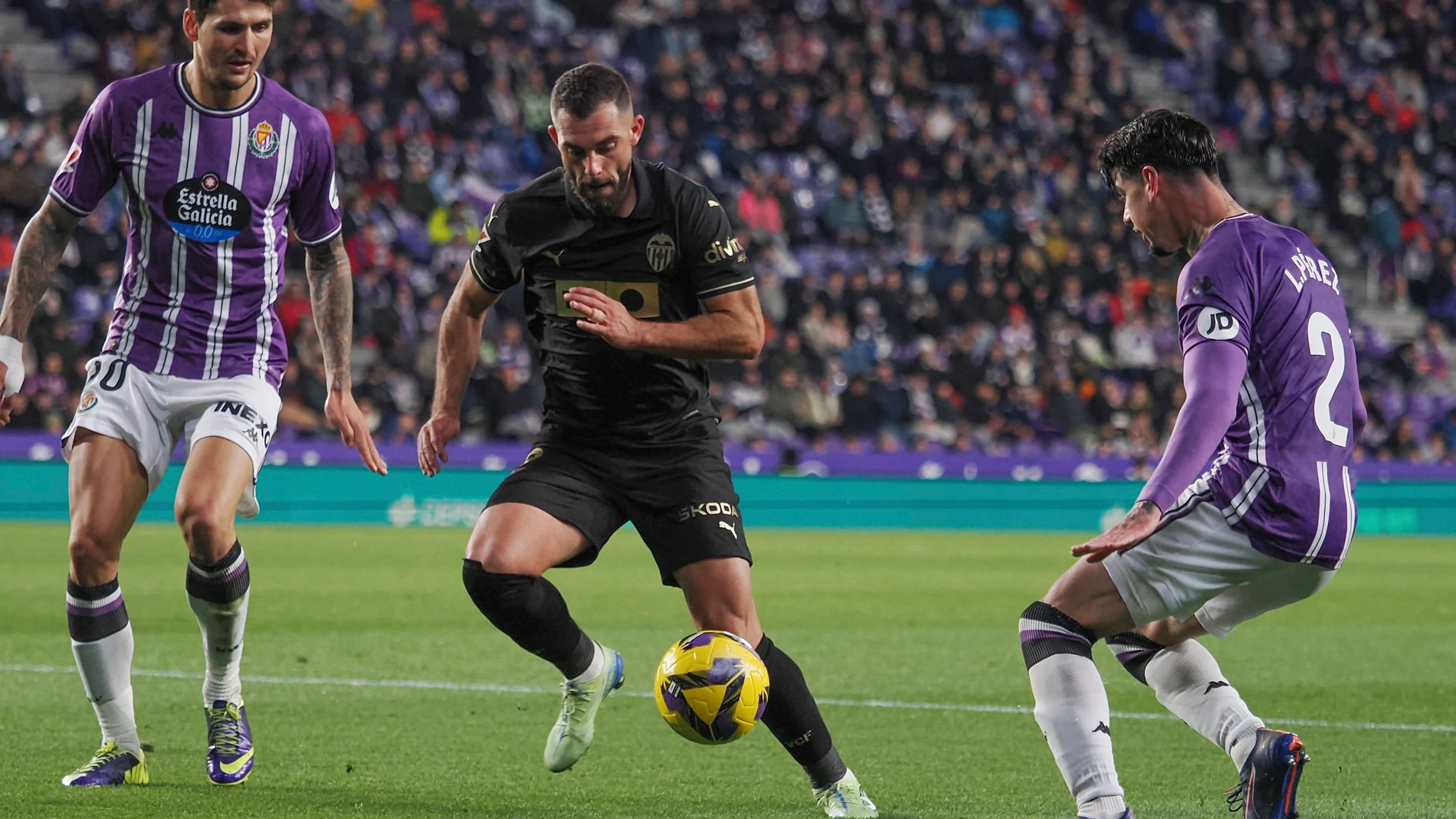 VALLADOLID. 13/12/2024.- El delantero del Valencia, Luis Rioja (c), con el balón ante los defensores del Valladolid, Luis Pérez (d) y el croata Stanko Juric, durante el encuentro correspondiente a la jornada 17 de Laliga EA Sports que disputan hoy viernes Valladolid y Valencia en el estadio José Zorrilla, en Valladolid. EFE/R. GARCIA.