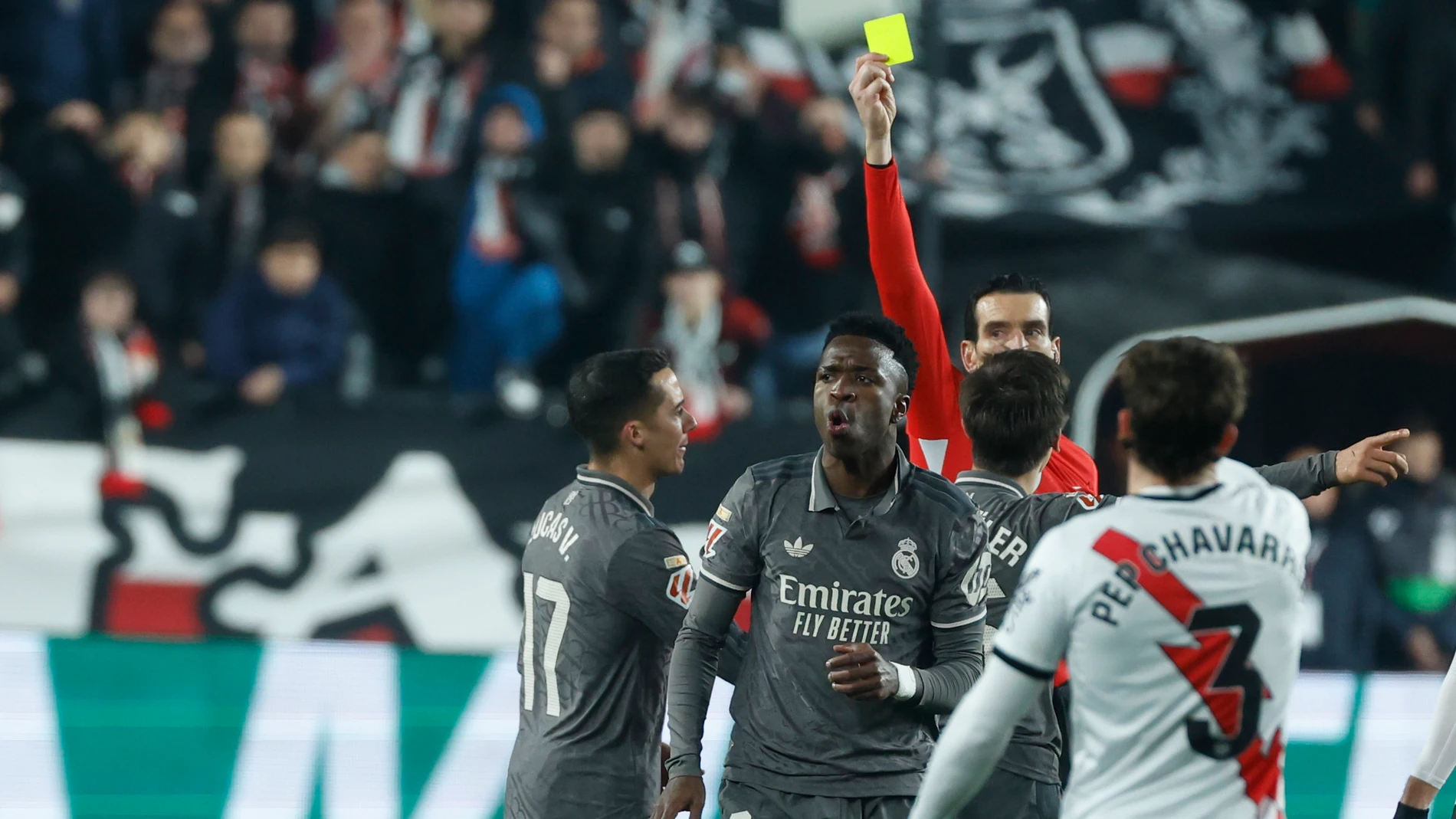 MADRID, 14/12/2024.- El delantero brasileño del Real Madrid, Vinicius Junior, recibe tarjeta amarilla durante el encuentro correspondiente a la jornada 17 de Laliga EA Sports que disputan hoy sábado Rayo Vallecano y Real Madrid en el estadio de Vallecas, en Madrid. EFE / Juanjo Martín.