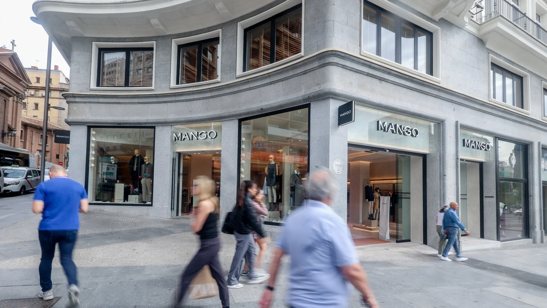 Varias personas pasan delante de la tienda de Mango, en Plaza de España,en Madrid.