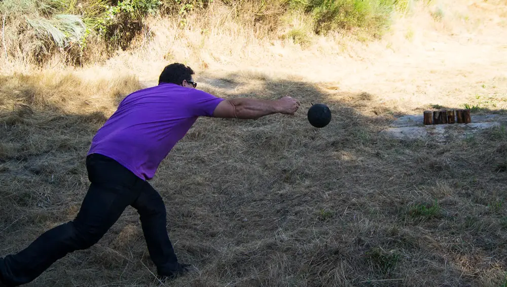 Un hombre jugando a los bolos gallegos
