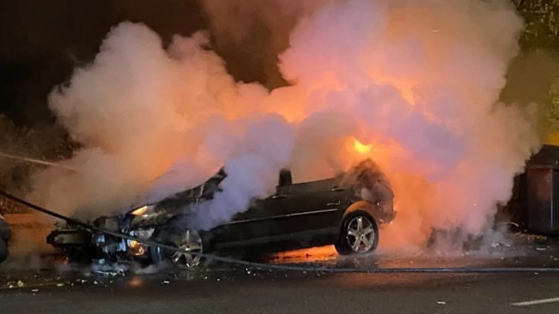 Uno de los coches que fueron quemados en el distrito