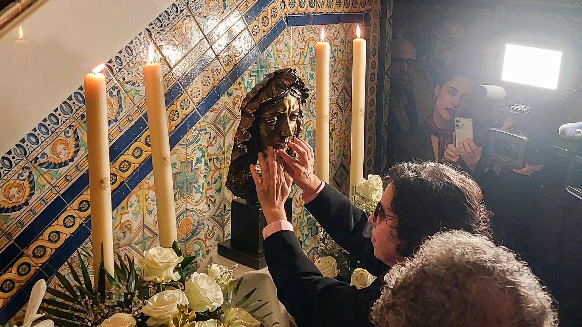 Una mujer invidente toca con sus manos el rostro de la réplica de la Virgen