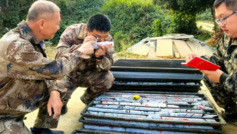 Técnicos del Instituto de Monitoreo y Estudios de Desastres Geológicos de la provincia de Hunan revisando varias muestras de rocas en el yacimiento aurífero Wangu, en el distrito de Pingjiang, provincia de Hunan. (Xinhua/Su Xiaozhou)
