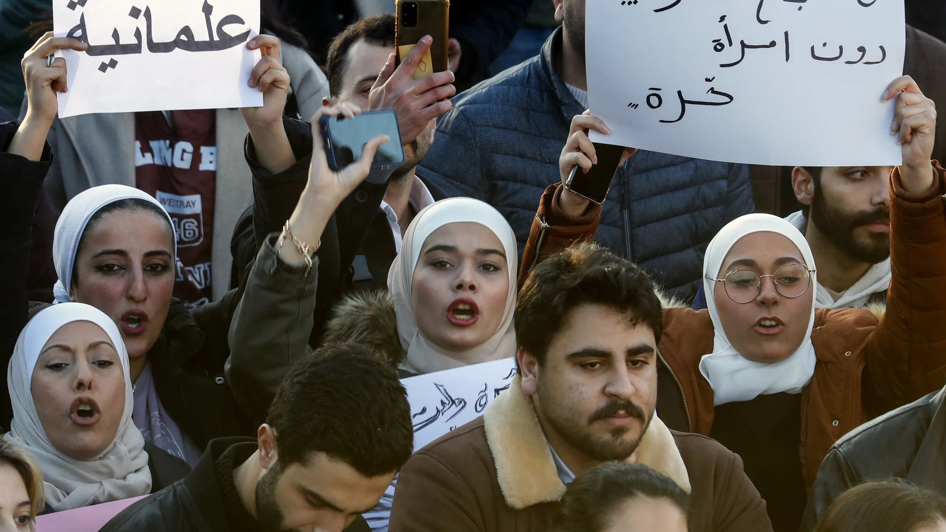 Syrian women chant slogans as they hold placards with Arabic that read: "No for free society without a free woman," right, and "Secularism," left, during a protest to demand a secular state, at the Umayyad square in Damascus, Syria, Thursday, Dec. 19, 2024.