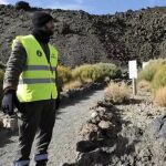Un agente medioambiental informa a una turista sobre la entrada en vigor de la nueva normativa sobre el acceso a pie al pico del Teide.